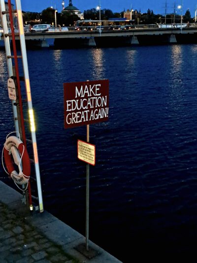 Stockholm Hafen mit Schild. Beschriftung: Make Education great again.