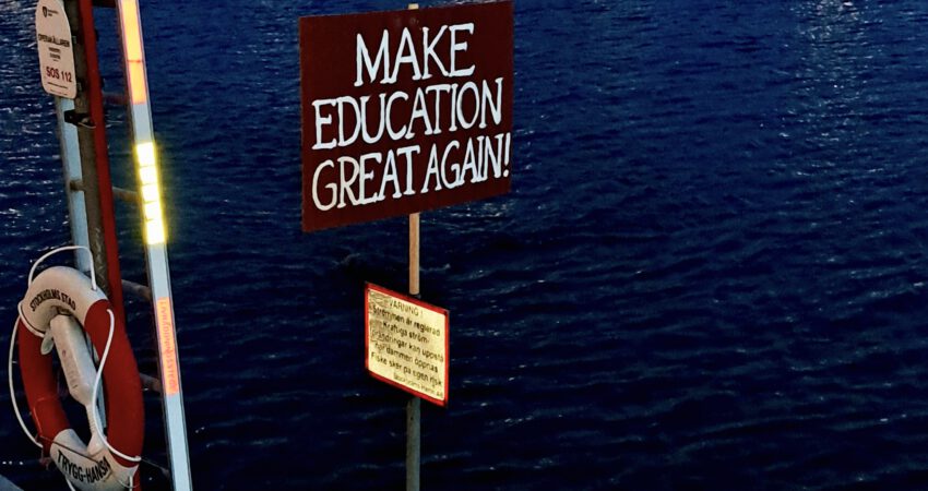 Stockholm Hafen mit Schild. Beschriftung: Make Education great again.